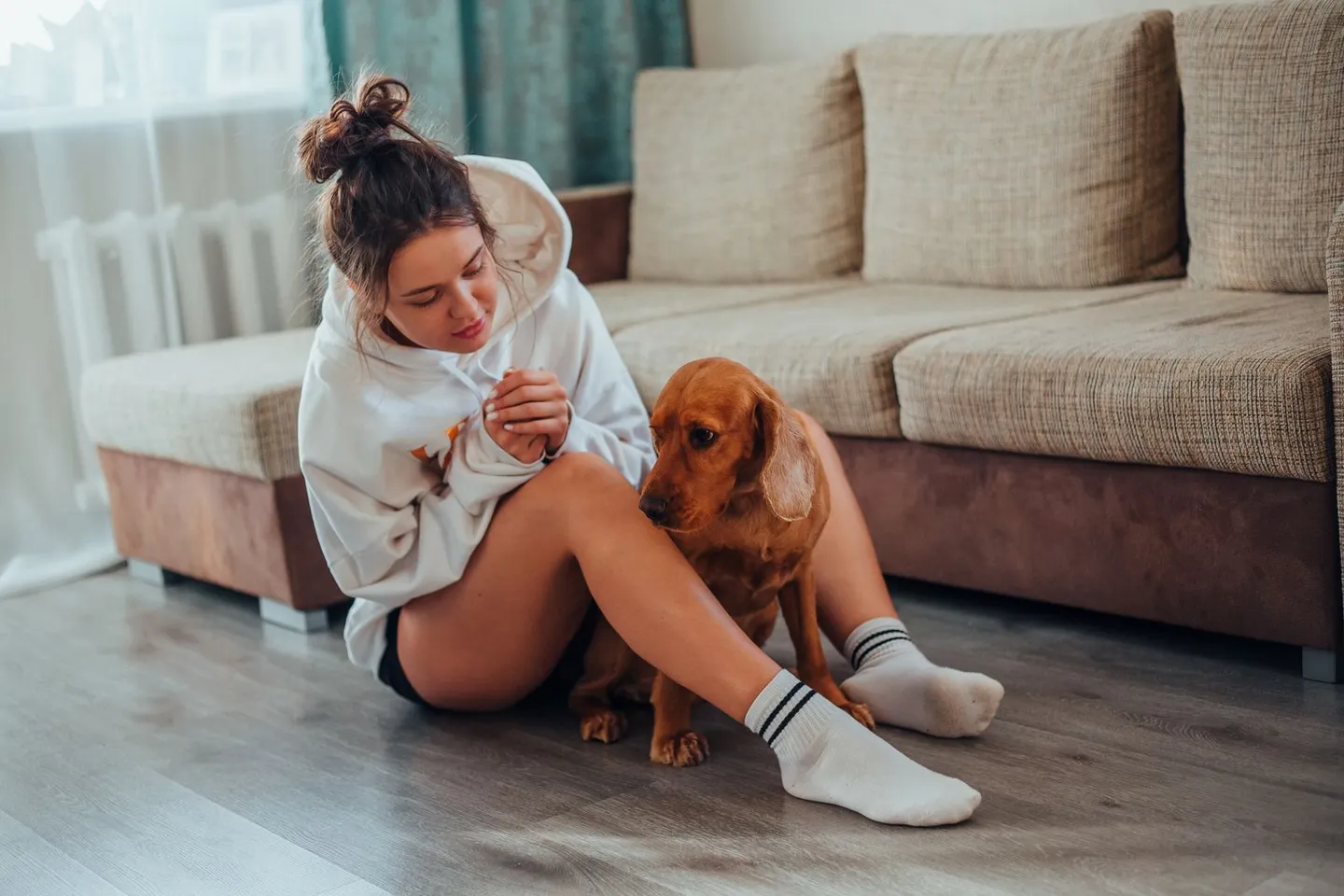 Woman sitting beside her dog in a living room