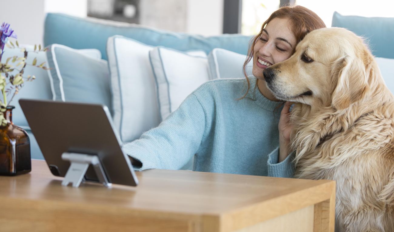 A licensed mental health provider reviewing a case during a telehealth visit, with a pet nearby