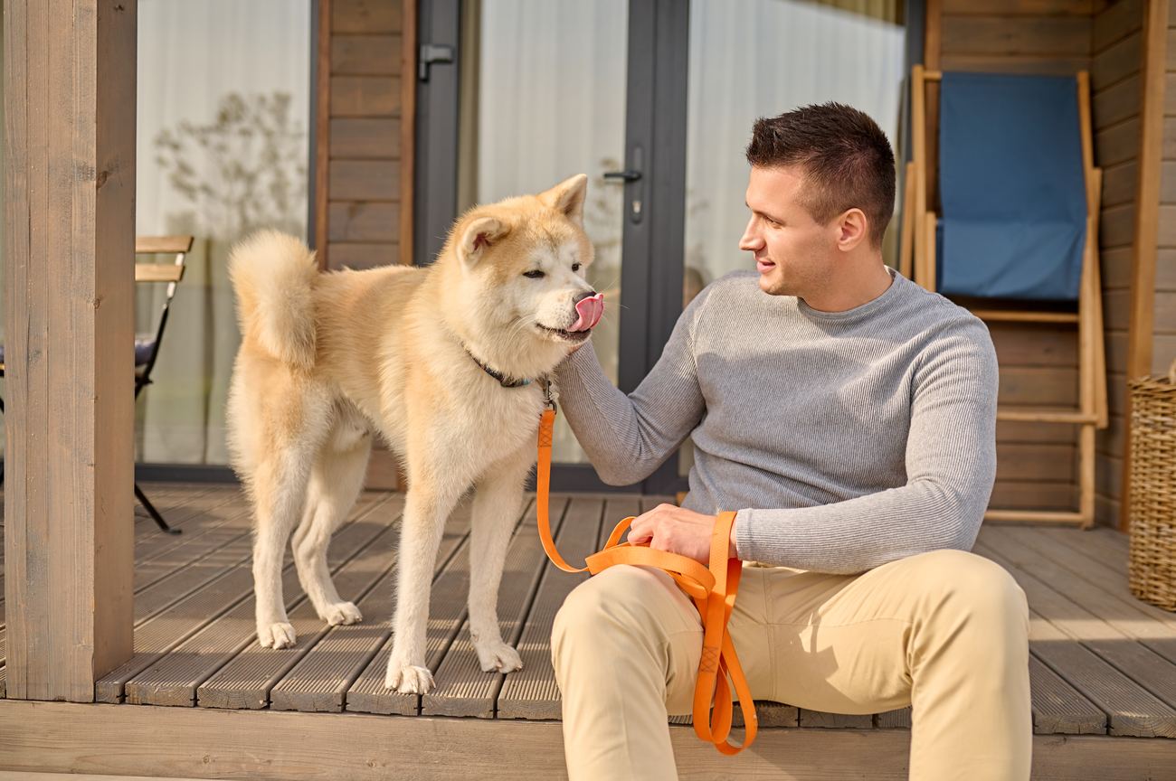 A veteran on his porch with his dog on a calm afternoon